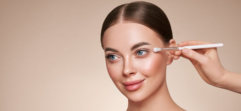 Makeup Artist applies Eye Shadow. Beautiful Woman Face. Perfect Makeup. Make-up detail. Beauty Girl with Perfect Skin
