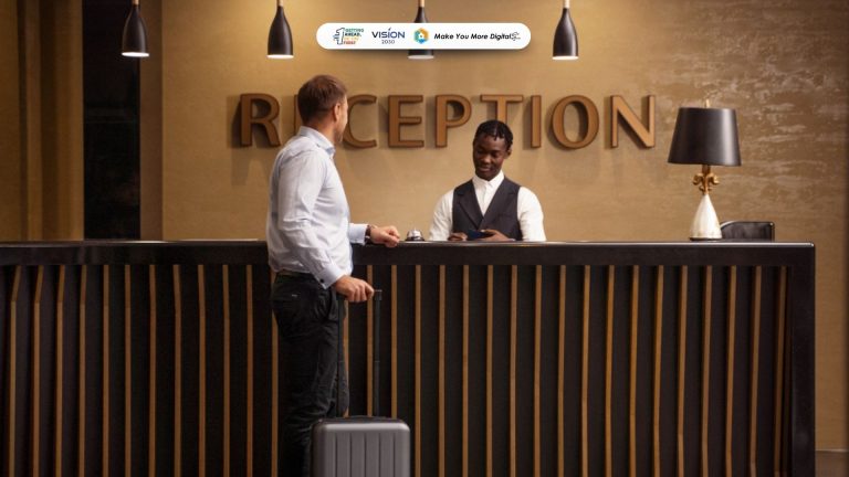 Staf front office hotel sedang melayani tamu di meja resepsionis dengan profesional